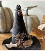 Black witch hat made out of felt and leaves.