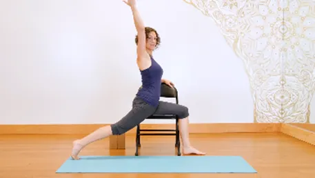 woman with a chair and mat doing a yoga pose
