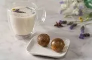 Tea bombs on a white dish with a tea cup filled with tea.