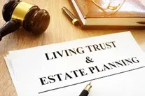 Living Trust and Estate Planning document, gavel and book on a desk.