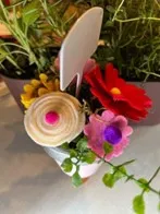 Different colorful felt flowers in a vase.
