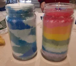 Two jars of candles with different colors in them.
