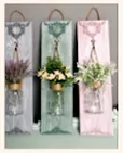 Wall hanging with flower vases with faux flowers.