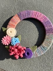 Colorful wreath with felt flowers and  wrapped with yarn