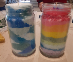 Two jars of candles with different colors in them.