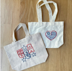 Two embroidered  canvas bags with "USA" and a patriotic heart on them.