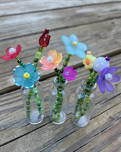 Tiny beaded flowers in different colors in a tiny vase.